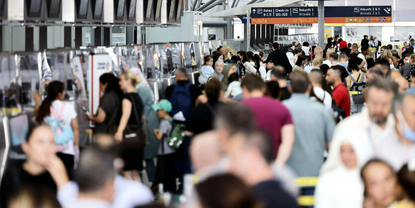 Menschen drängen sich vor dem Check-In im Flughafen Köln.