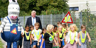 Einige Kinder in gelben Westen laufen neben einem Zebra-Maskottchen vor CDU-Spitzenkadidat Bernd Althusmann