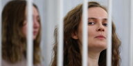 Zwei Frauen hinter Gitterstäben