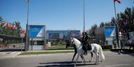 Zwei Polizisten patrouillieren per Pferd das Messezentrum, wo der Gipfel stattfindet.