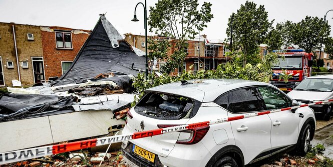 Ein abgedecktes Hausdach, Schutt und ein beschädigtes Auto in Zieriksee.