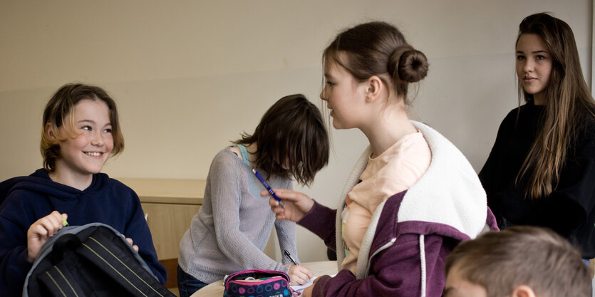 Maedchen unterhalten sich ein einem Klassenzimmer