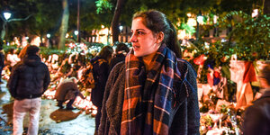 Eine junge Frau steht trauernd vor dem Bataclan in Paris