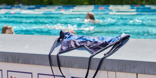 Ein badeoberteil liegt am Rand eines Schwimmbeckens