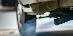 Bläuliche Rauchwolken stößt der Dieselmotor eines Kleinlasters aus