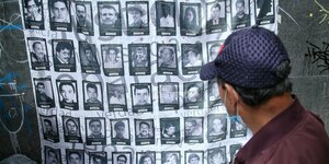 Ein Mann betrachtet Bilder von Todesopfern des internen Konflikts in Kolumbien