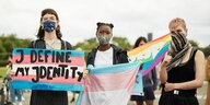 3 Personen mit Transgender-Flagge demonstrieren vor dem Reichstag in Berlin