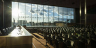 leerer Saal der Bundespressekonferenz, eine große Fensterfront legt den Blick auf schöne Wolken frei