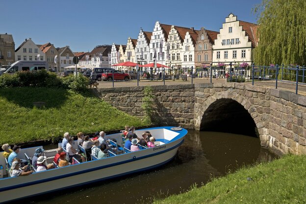 Ausflugsboot in einer Gracht vor der Kulisse von Friedrichstadt Ausflugsboot in einer Gracht vor der Kulisse von Friedrichstadt