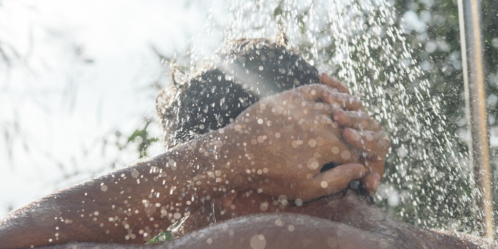 Männerrücken unter der Dusche.