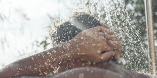 Männerrücken unter der Dusche.