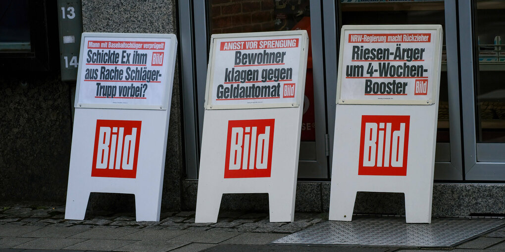 Drei Bildaufsteller vor einem Kiosk