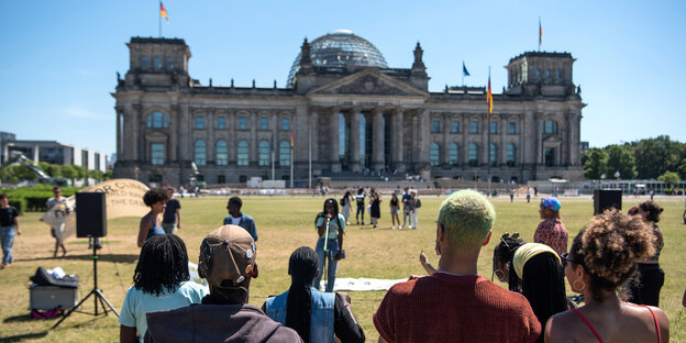Menschen protestieren vor dem Berliner Reichstag