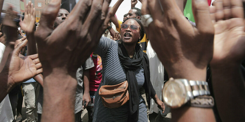 Menschen protestieren mit einer sudanesischen Fahne