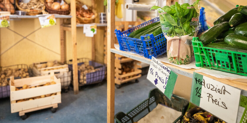 Gemüsekisten vor Regalen mit Zwiebeln ud Kartoffeln in einem Bioladen