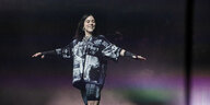 Die Musikerin Billie Eilish in schwarzerweißer Sportkleidung während eines Konzerts