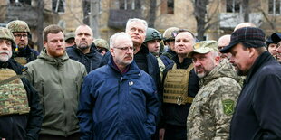 Eine Gruppe von Personen, einige tragen Uniform oder Schutzwesten