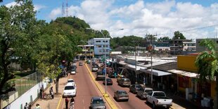 Straße in Puerto Ayacucho, im Hintergrund ein grüner Hügel mit Sendemasten