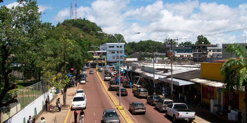 Straße in Puerto Ayacucho, im Hintergrund ein grüner Hügel mit Sendemasten