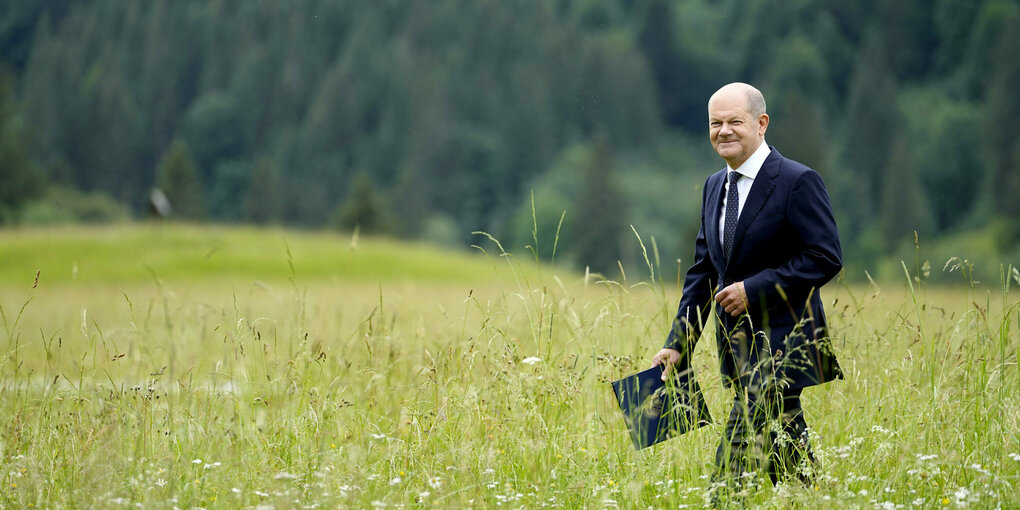 Olaf Scholz läuft über eine Wiese