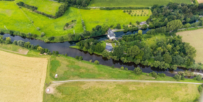 Blick von oben auf Grün und kleines Wasserkraftwerk