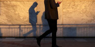 Der Schatten eines Mannes mit Smartphone