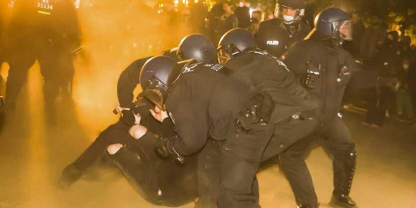 Eine GGruppe im Polizisten hat sich im nächtlich beleuchteten Nebel auf eine Person gestürzt