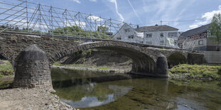 Eine alte Steinbrücke mit einem Stahlgestell über dem Fluss Ahr