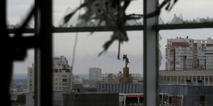 Zerstörte Häuser, gesehen aus einem Fenster mit zerstörten Scheiben