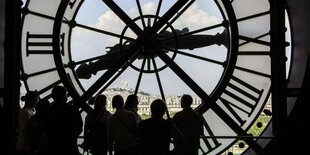 Menschen stehen vor der alten Bahnhifsuhr im Musée d'Orsay in Paris