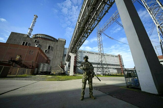 Ein bewaffneter russischer soldat vor dem Saporischschja Atomreaktor