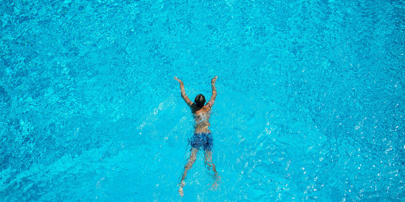 Eine Frau schwimmt im Freibad