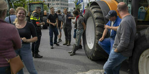 Menschen und Traktoren stehen auf einer Straße