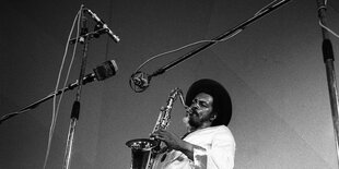 Albert Ayler steht mit Sopransaxofon und in weißem Gewand auf der Bühne.