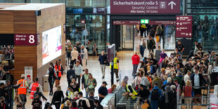 Menschen warten am Flughafen BER in einer Schlange