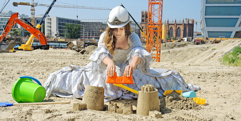 Eine Frau sitzt im Sand