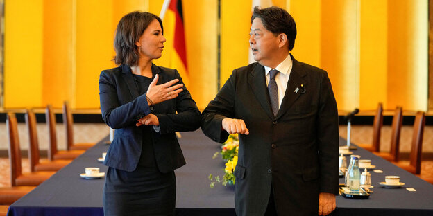 Annalena Baerbock und der japanische Aussenminister Yoshimasa Hayashi begrüßen sich coronakonform