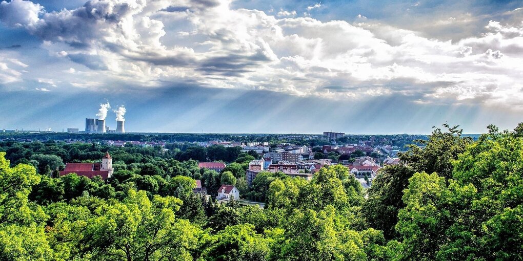 Landschaft mit Stadt und Kraftwerk im Hintergrund