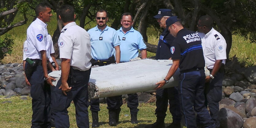 Französische Polizisten mit dem Wrack auf La Réunion