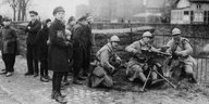 Französische Soldaten im Jahr 1923 an einem Maschinengewehrposten, daneben Zivilisten