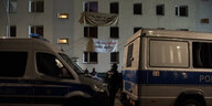 Die verkleidetete Fassade der Habersaathstraße an der ein Transparent mit der Aufschrift: Wir wollen ein Zuhause steht, davor zwei Polizeiautos