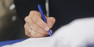 Hand mit Stift bei einer Unterzeichnung