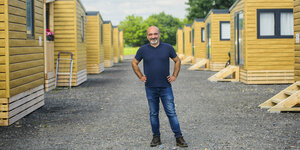 Ein Mann steht zwischen kleinen gelben tiny houses