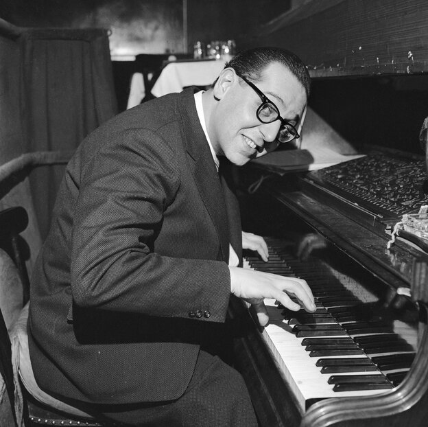 Schwarz-Weiß-Foto eines Mannes mit Brille am Klavier