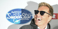 Dieter Bohlen mit Sonnenbrille vor DSDS Logo