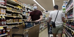 Zwei Männer mit Einkaufswagen in einem Supermarkt