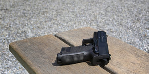 Eine Pistole P8 liegt auf einem Hocker