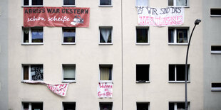 Plakate hängen vor einem Haus