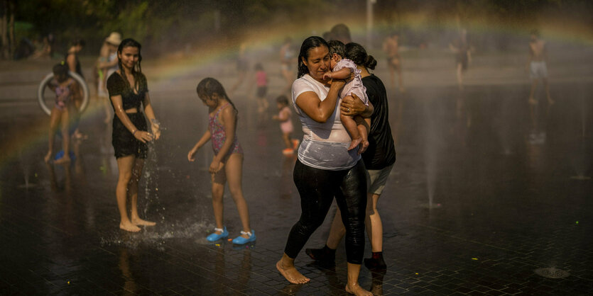 Menschen kühlen sich ein einem Brunnen ab