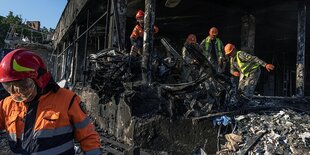 Feuerwehrleute an dem Ort eines Raketeneinschlags